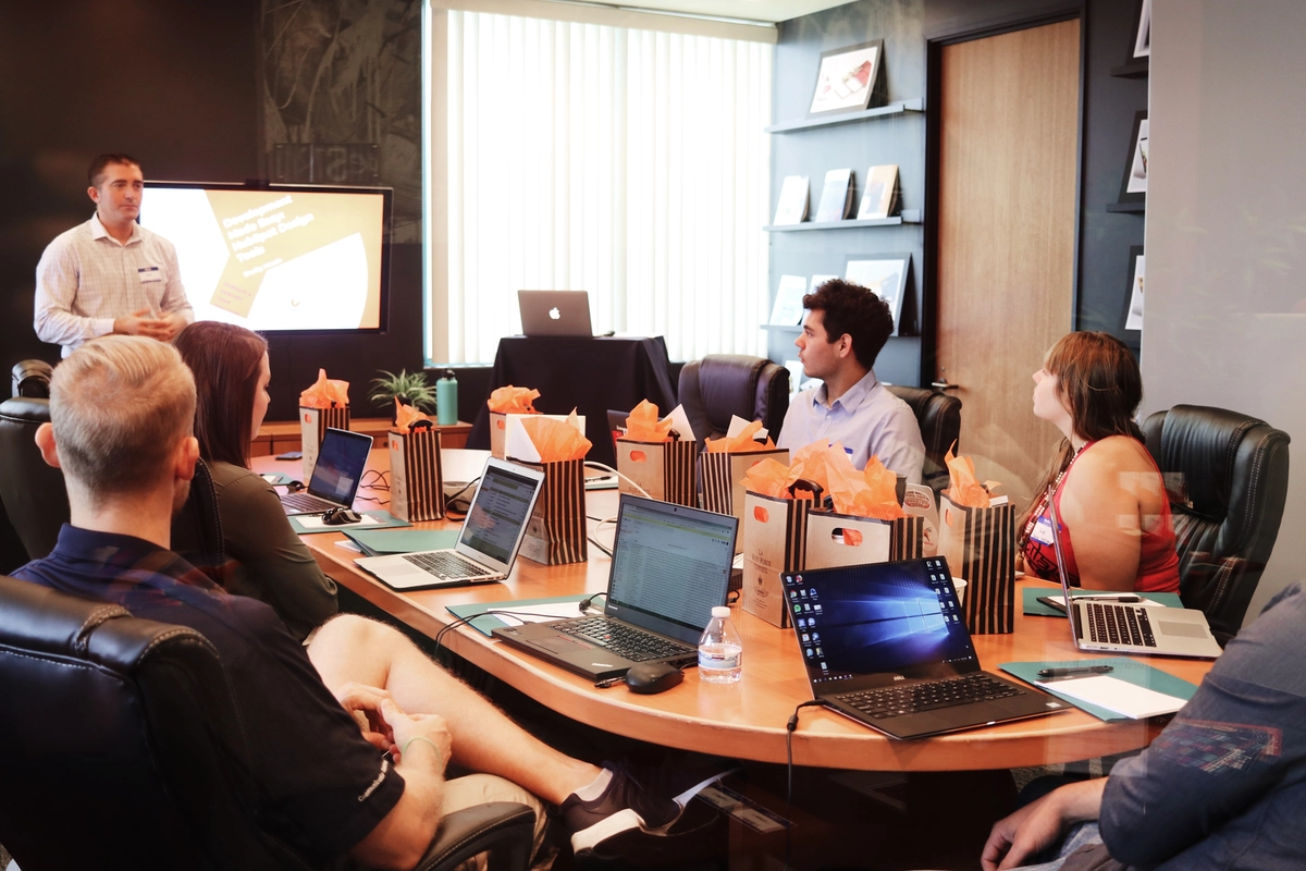 A group of employees attending a marketing presentation in a small conference room.